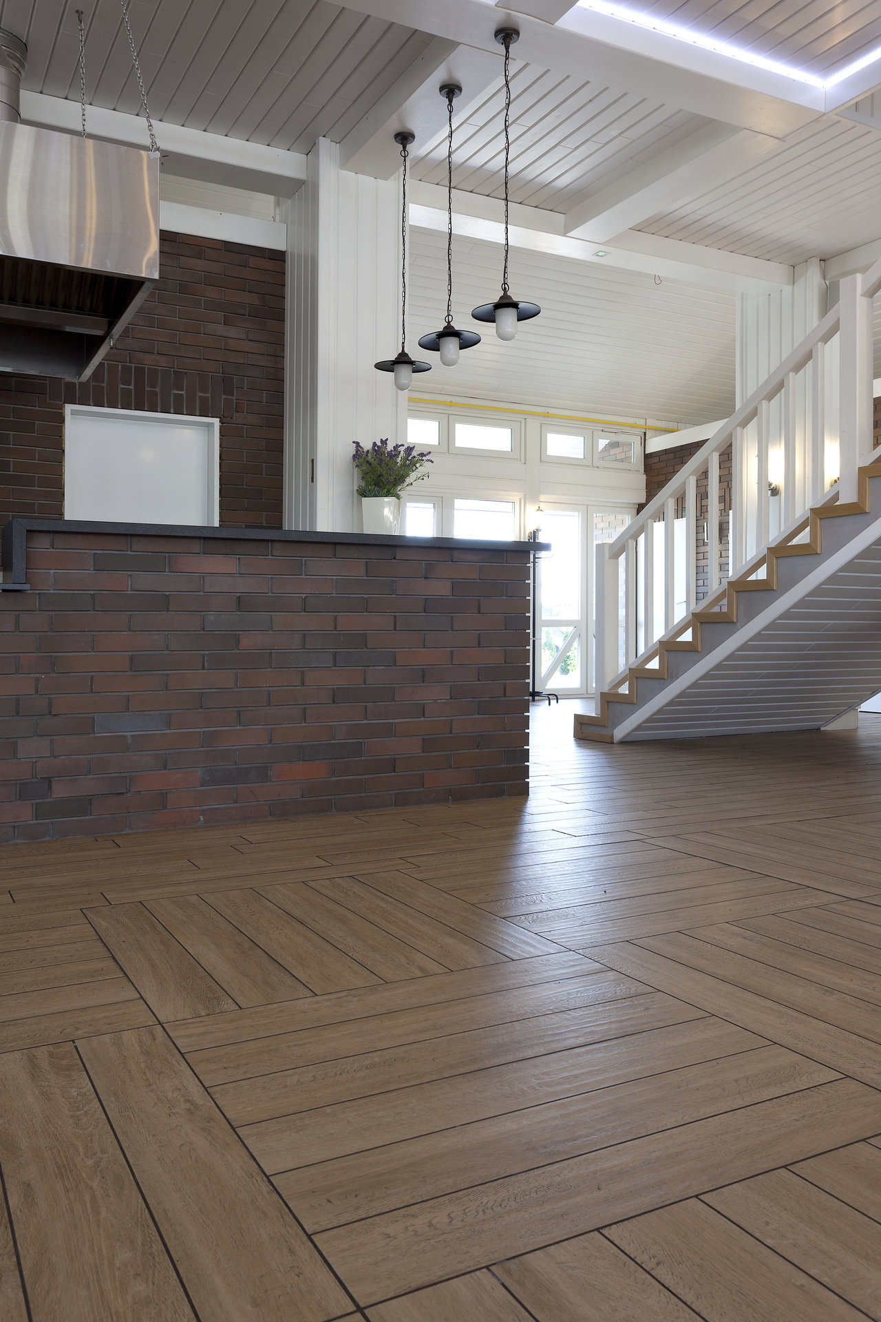 Bright living room with wood-effect cube pattern floor tiles and brick-effect wall tiles.