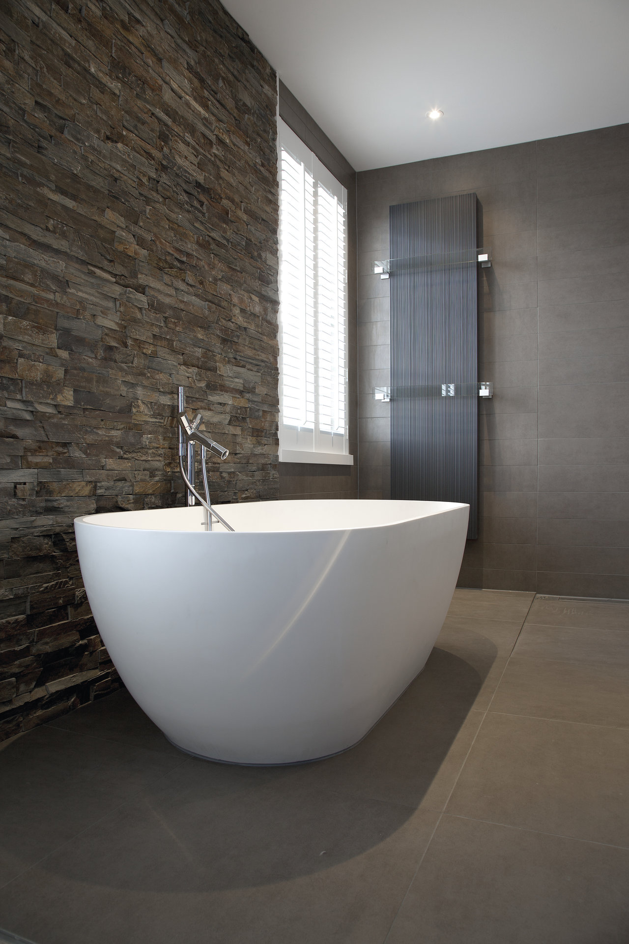 High-quality tiles: Natural stone effect on walls, large-format tiles on floor in modern bathroom.