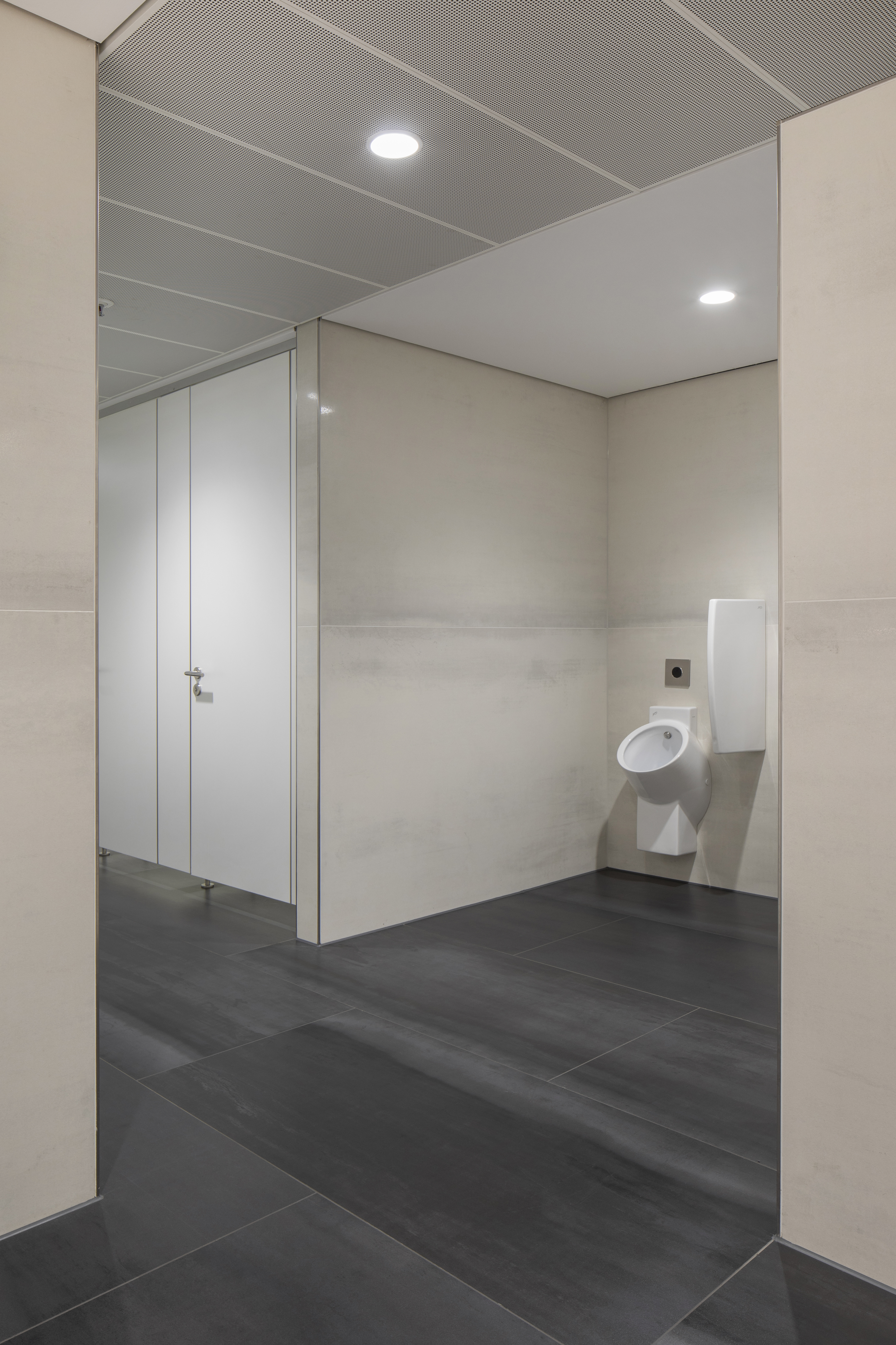 High-quality tiles in dark grey and light beige in a modern bathroom.