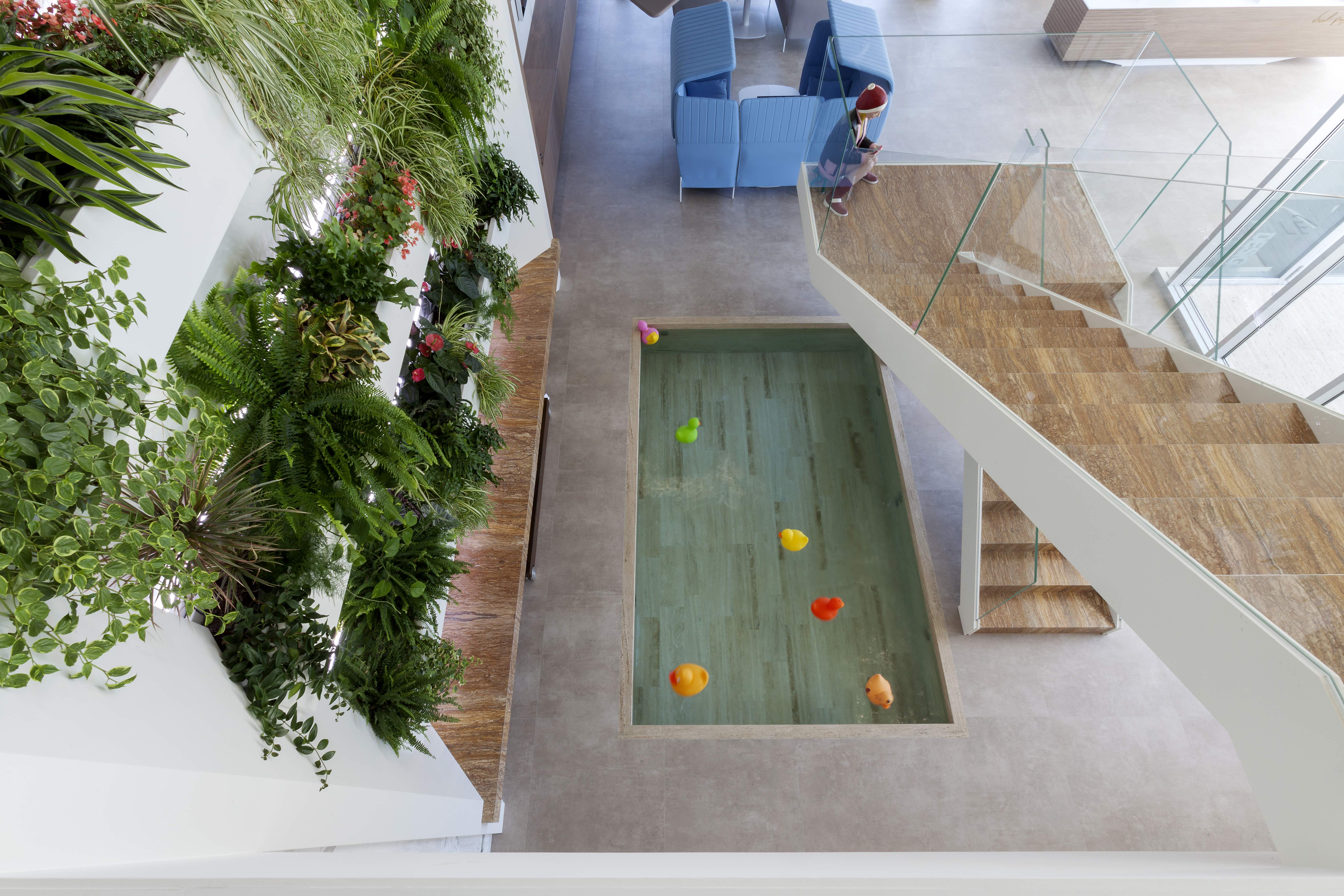Stylish interior with high-quality floor tiles, wooden staircase, and plant wall.