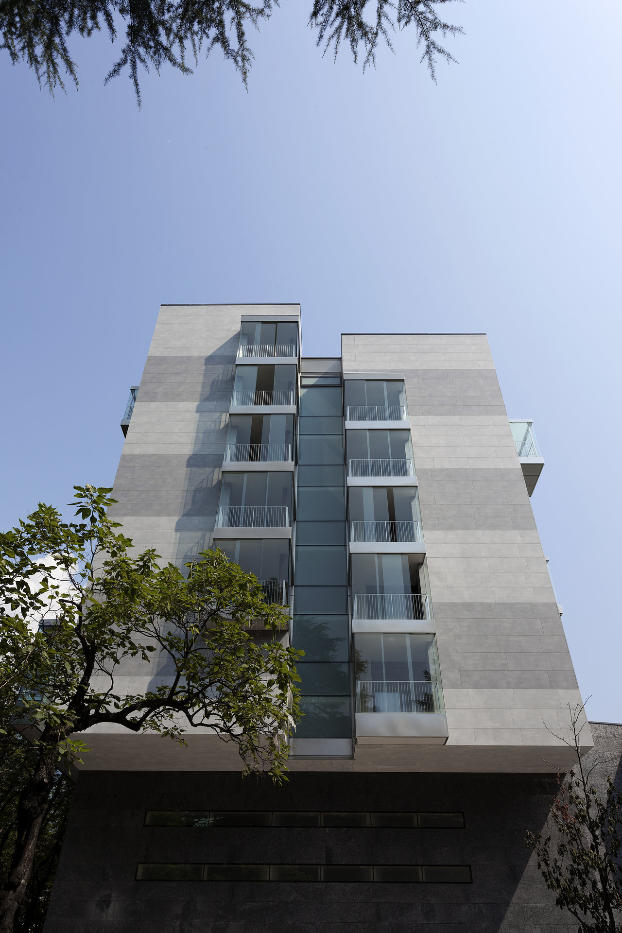 Modern building with striped grey tile facade and glass fronts.
