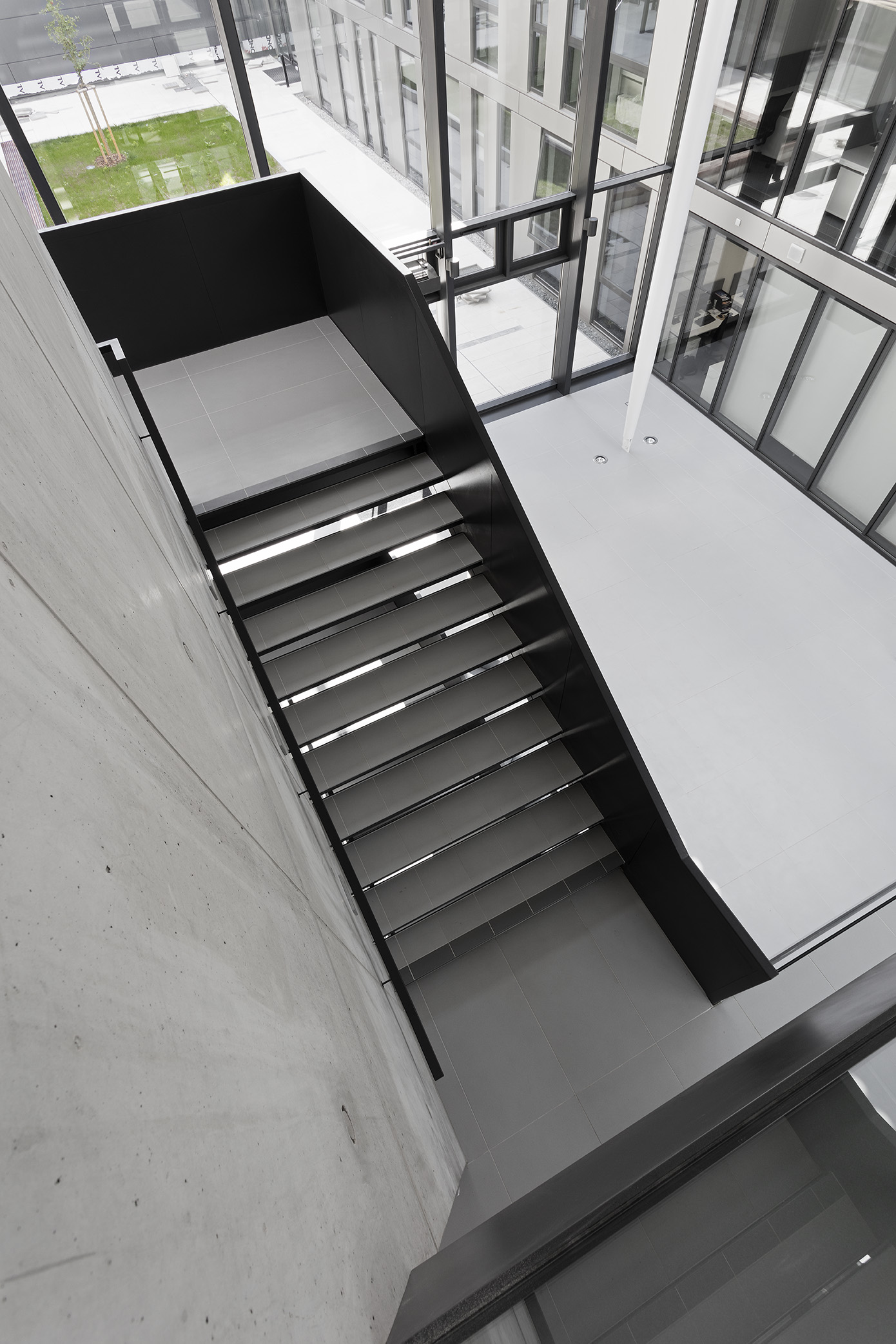 Light-coloured, modern floor tiles in a sunlit stairwell.