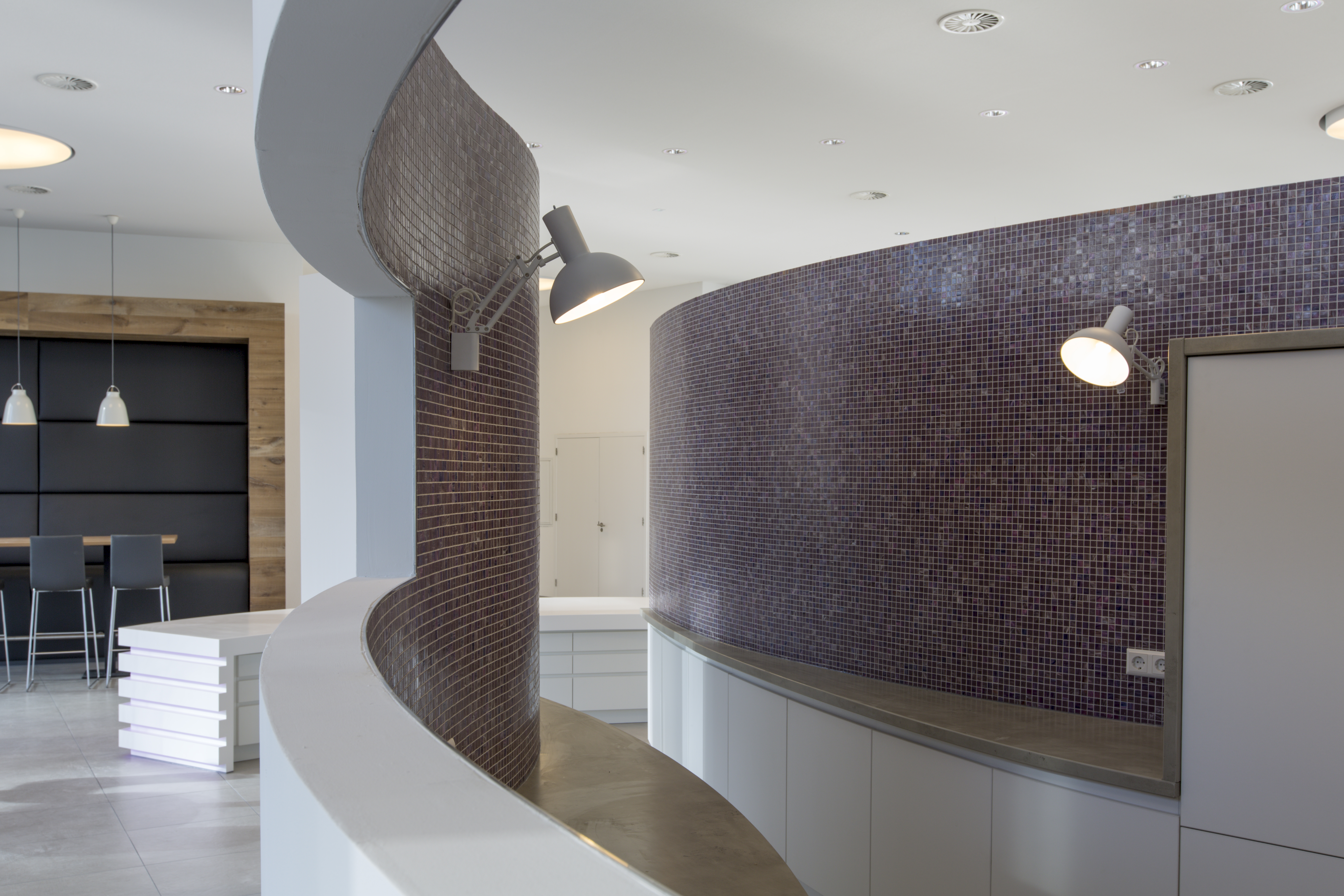 Elegant tile solutions: Mosaic and brick look on curved walls.