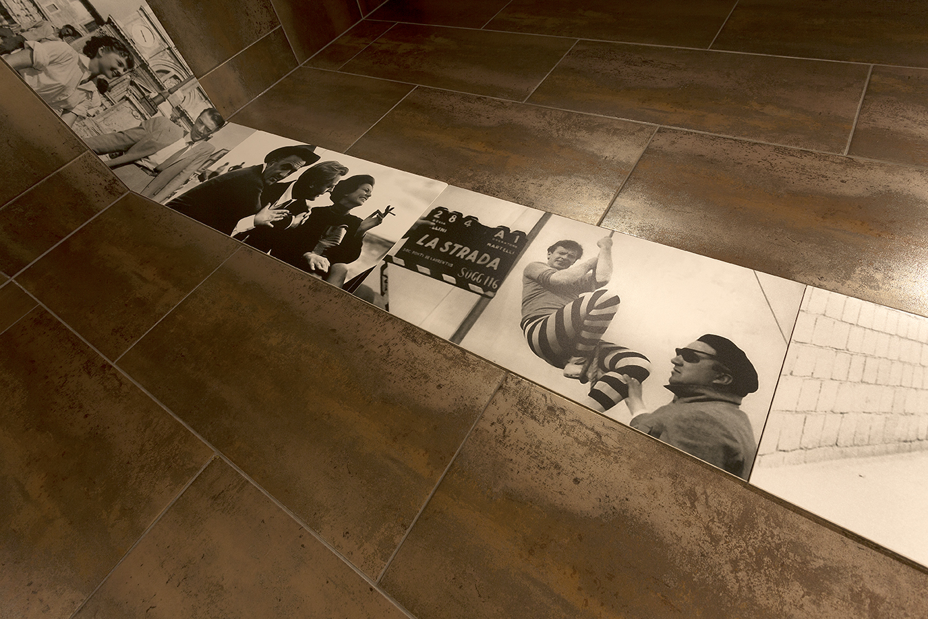 Rust-effect floor tiles with integrated B&W filmstrip design.