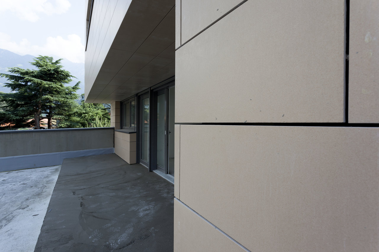 Light facade tiles and dark patio tiles on a modern building.