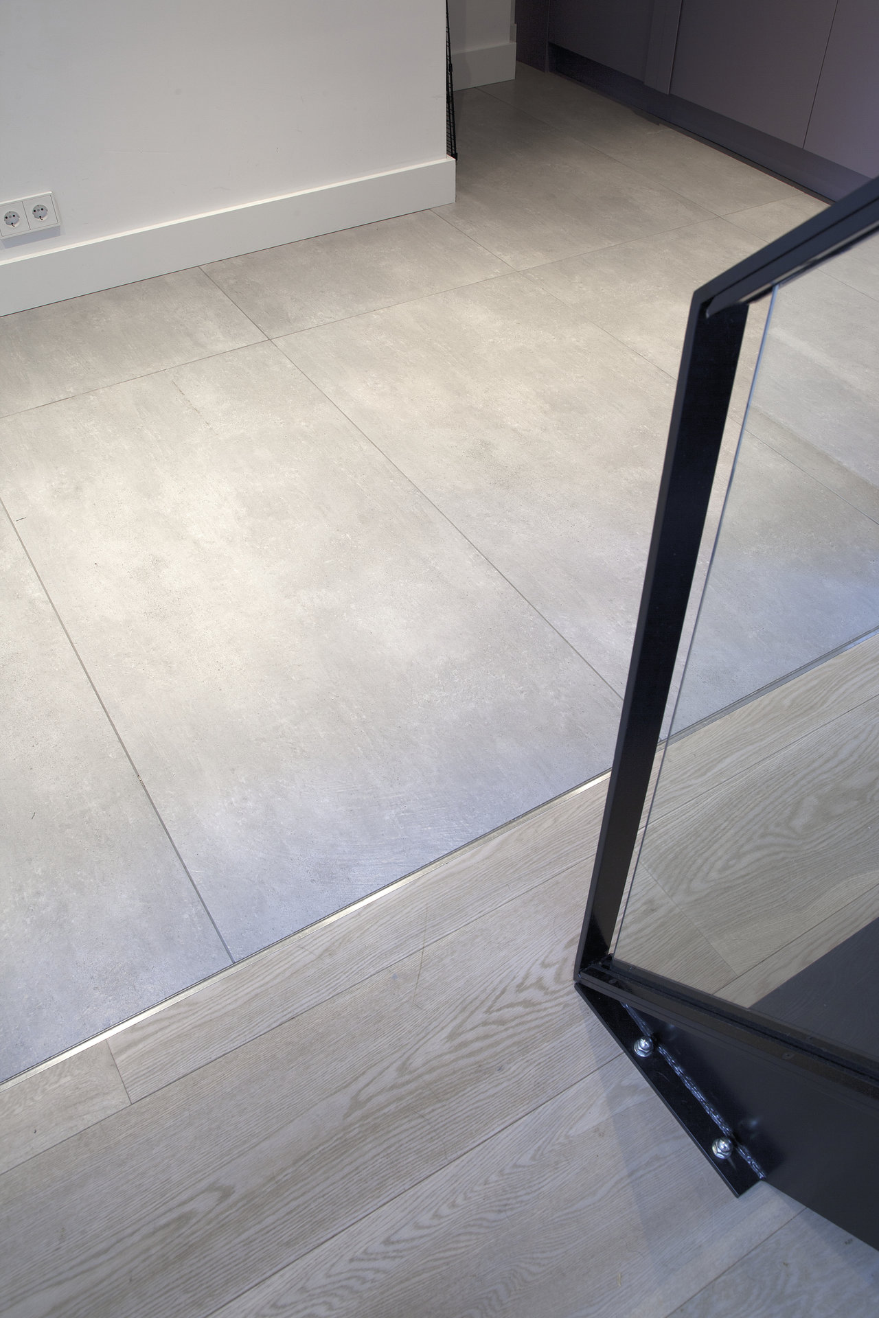 Grey tiles and wooden floor with clean transition profile.