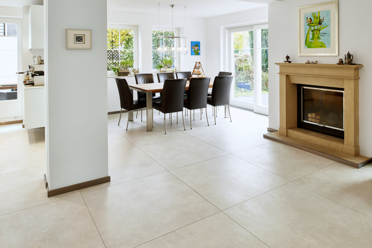 Light, large-format tiles in a modern living & dining area with fireplace.