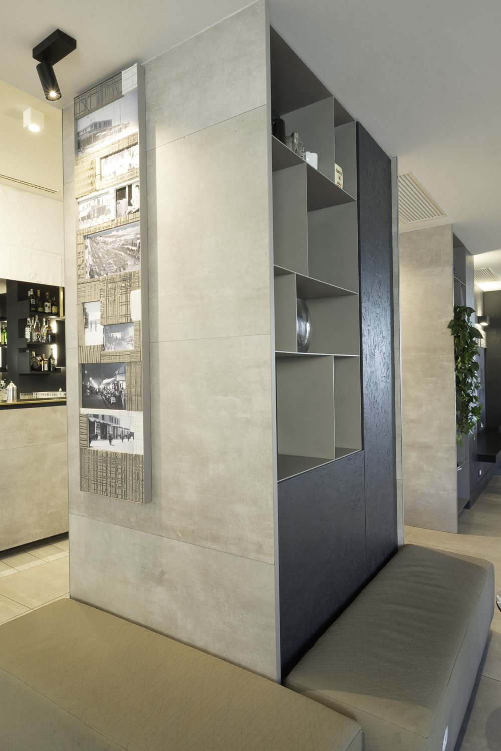 Light concrete-effect tiles as a room divider with integrated shelf and benches.