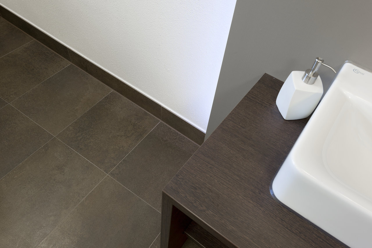 High-quality dark floor tiles and vanity top.