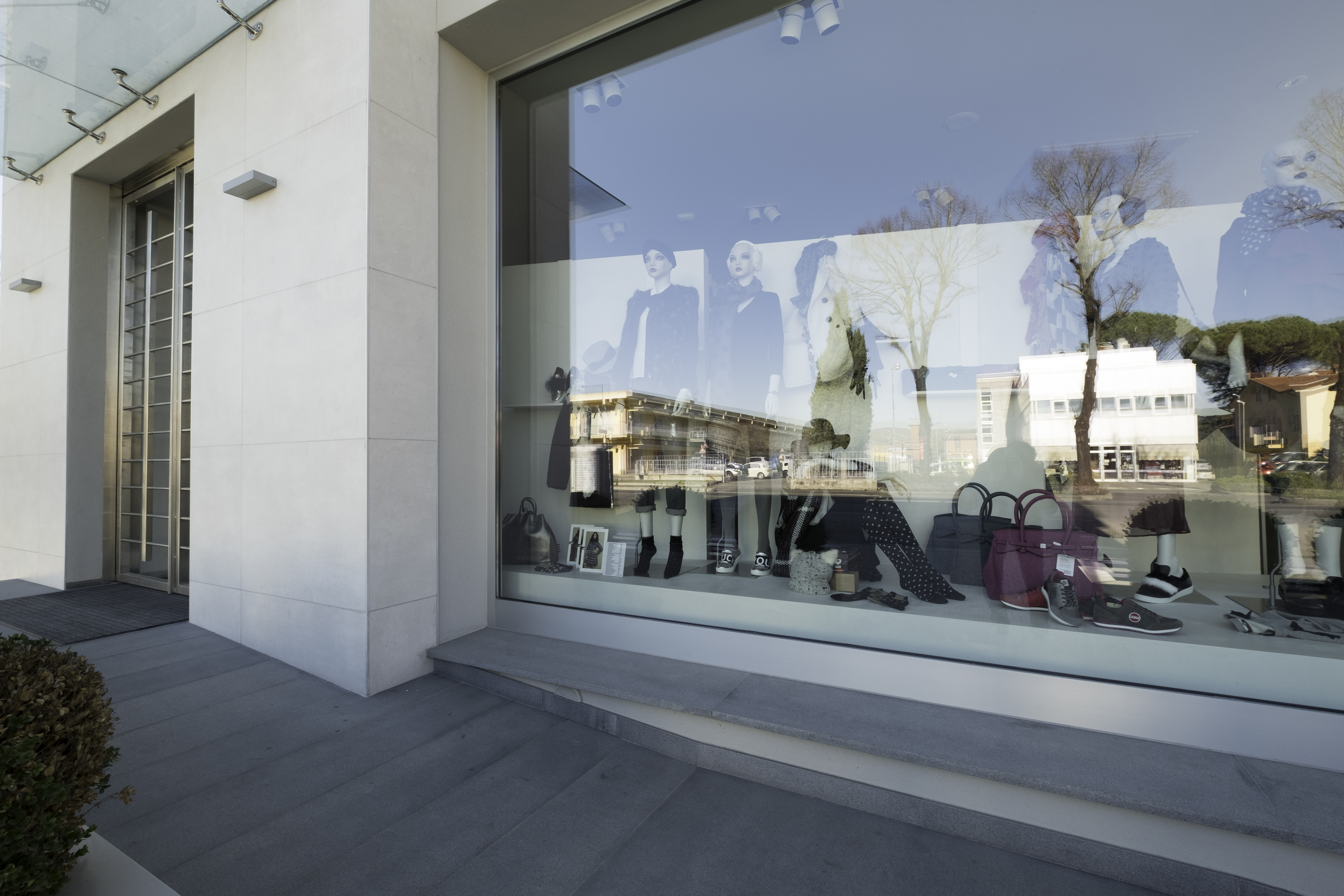 Dark grey outdoor tiles in front of a modern building.