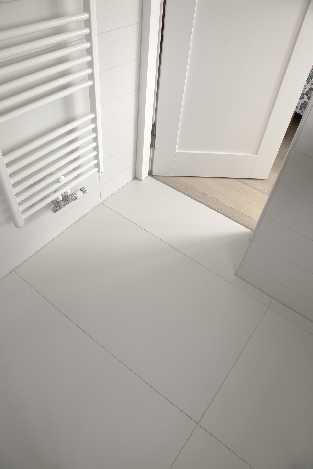 Large-format light floor tiles in a modern bathroom.