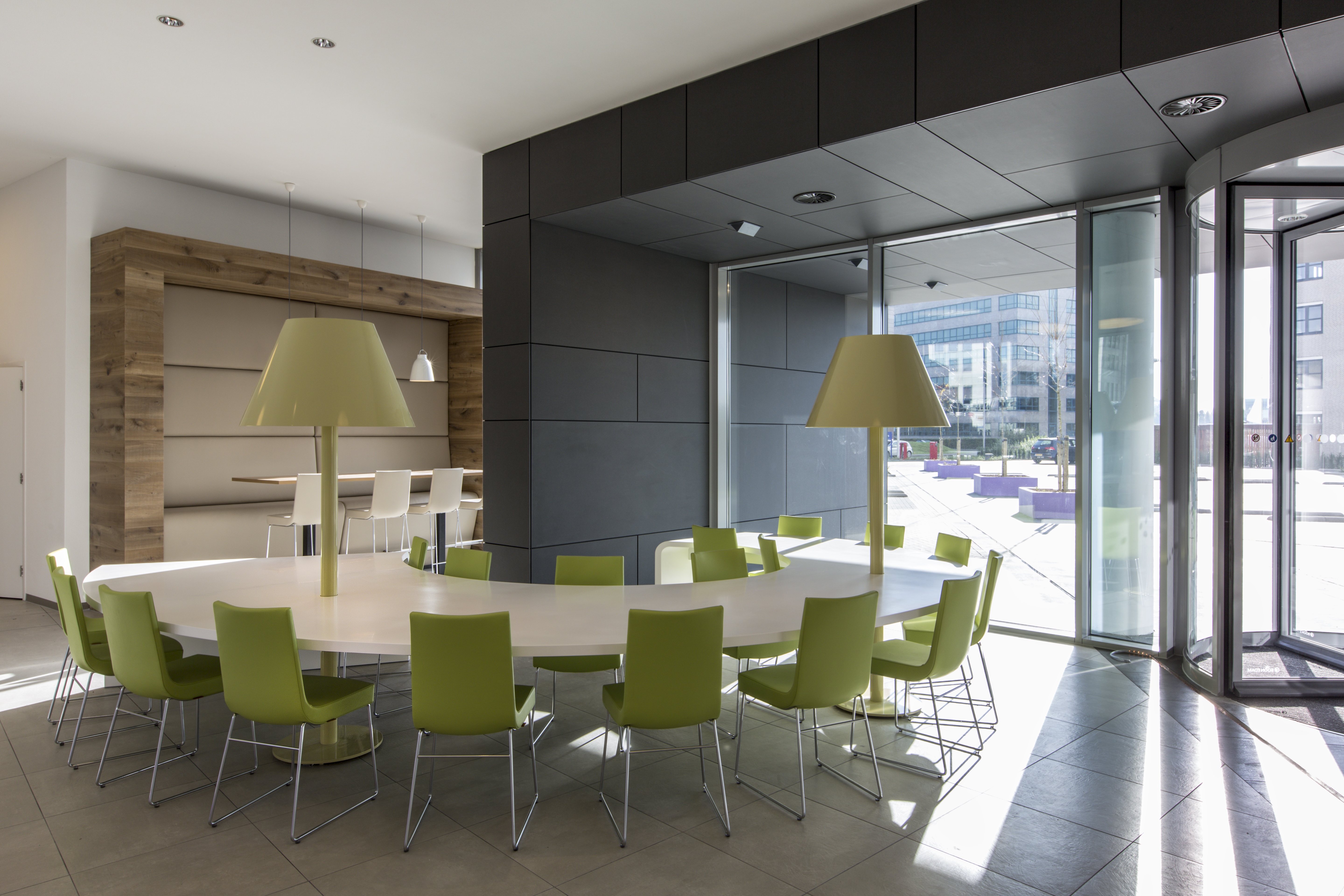 Elegant meeting area with modern tile floor and green chairs.