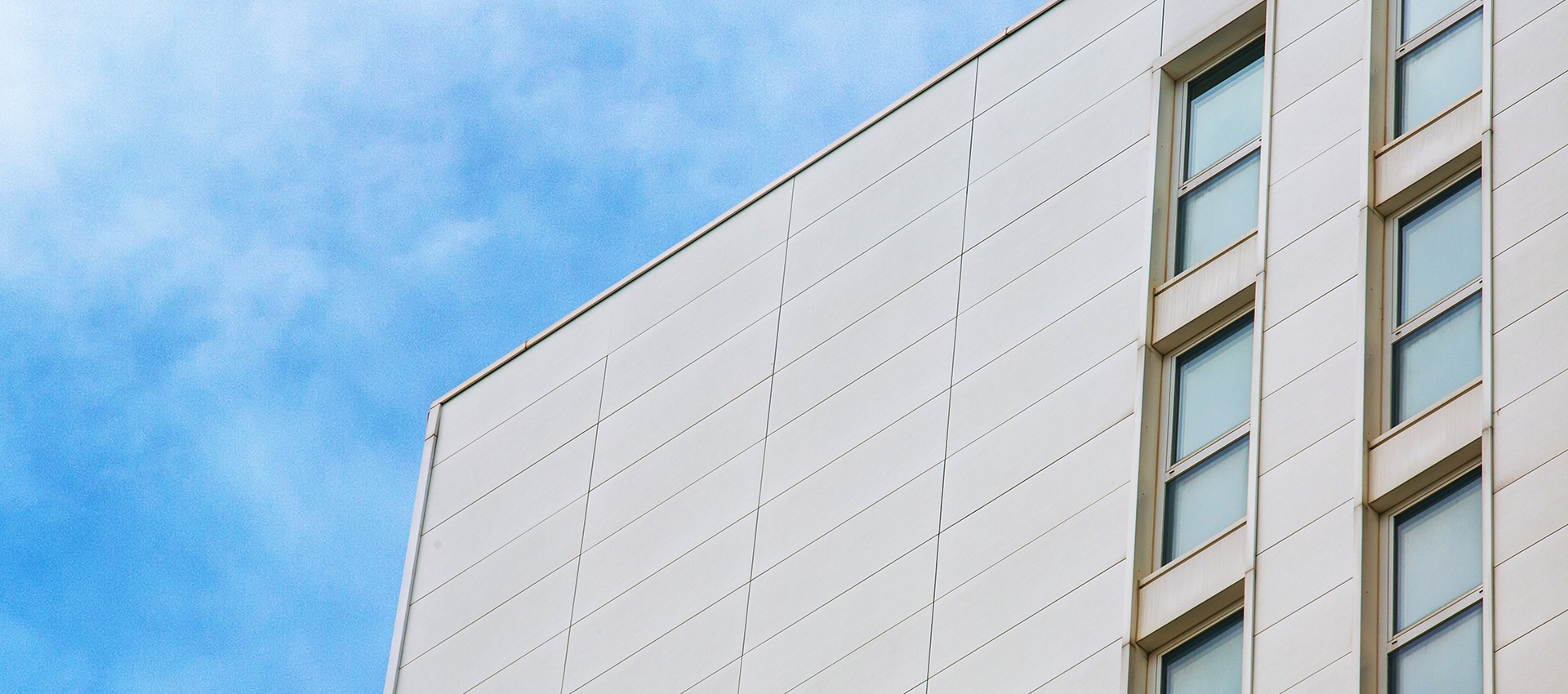 Bright, modern facade with large-format tiles & windows, ideal for exteriors.