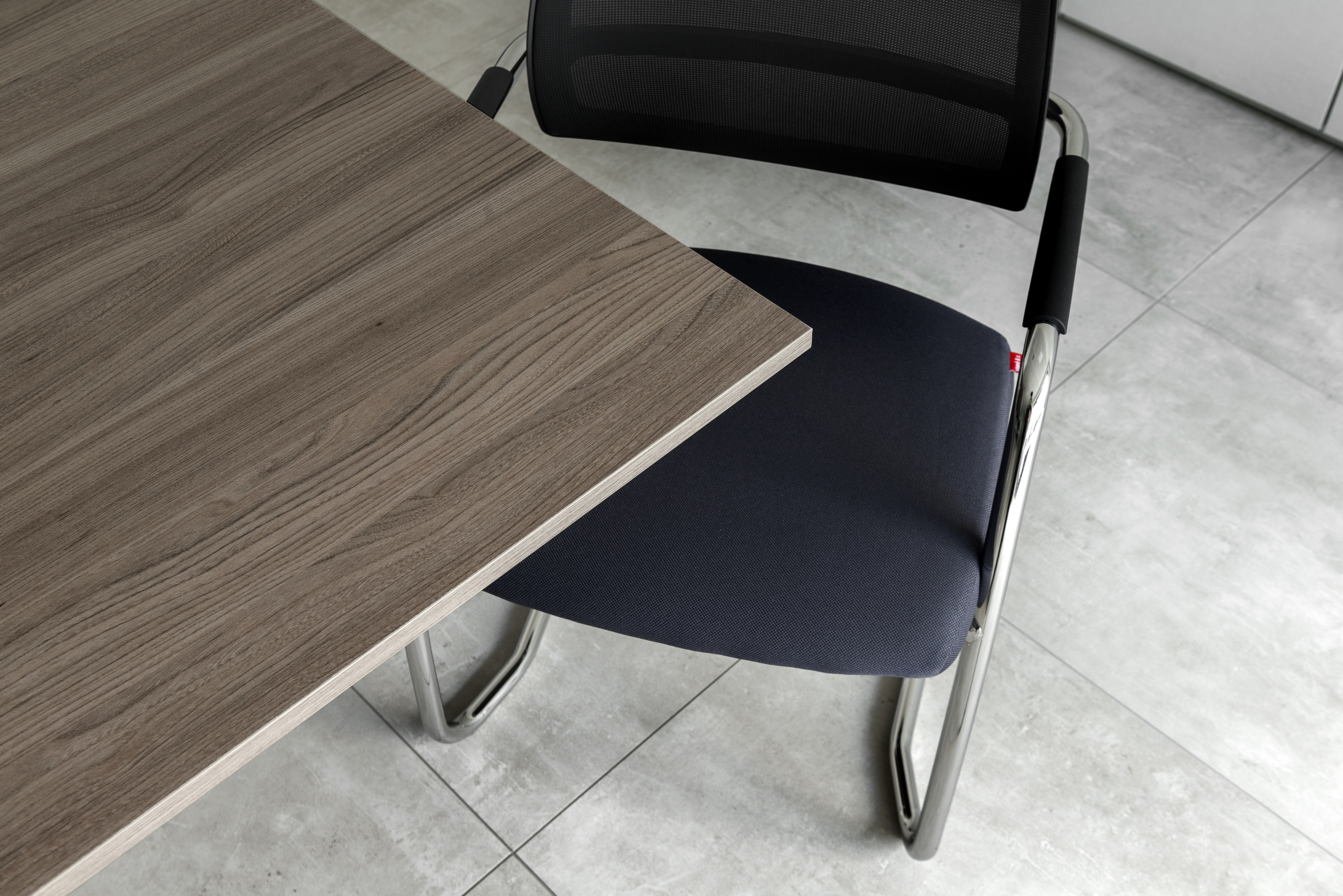 Indoor light grey tiles with wooden table and chair.